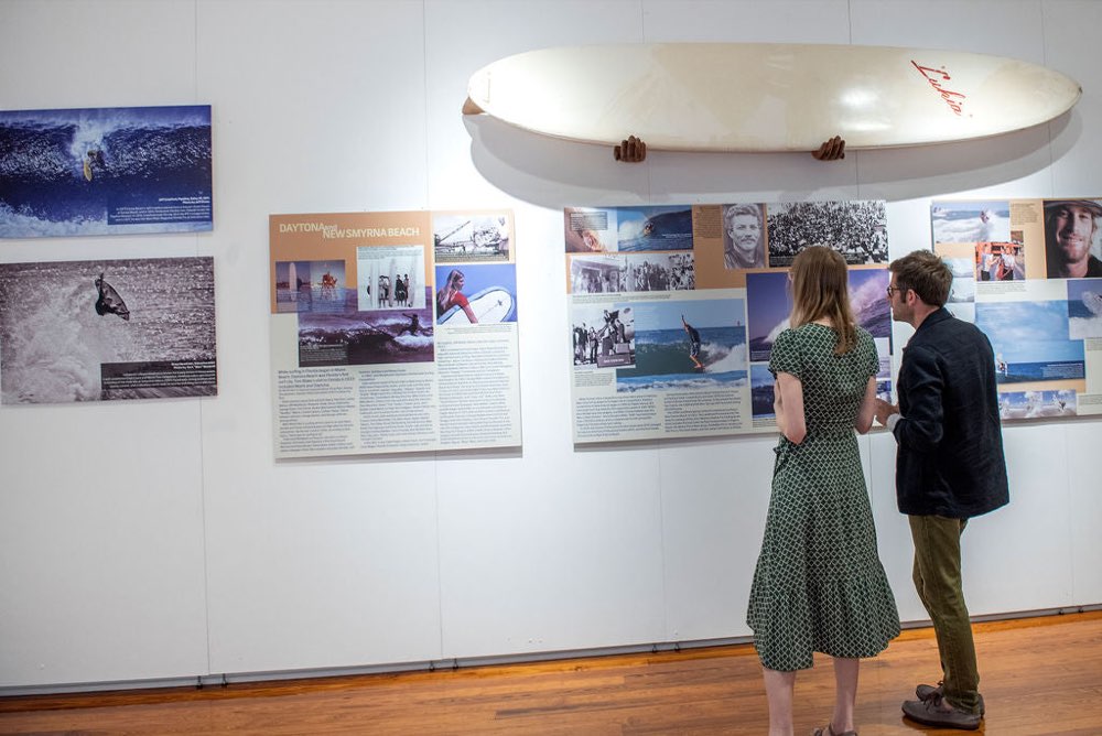 Visitors reading Surfing Florida history panels at the Cornell Art Museum