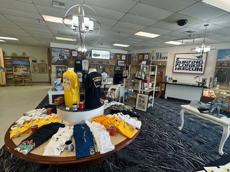 The museum gift shop, with surf club tees, hats, books and the Surfing Florida Museum sign